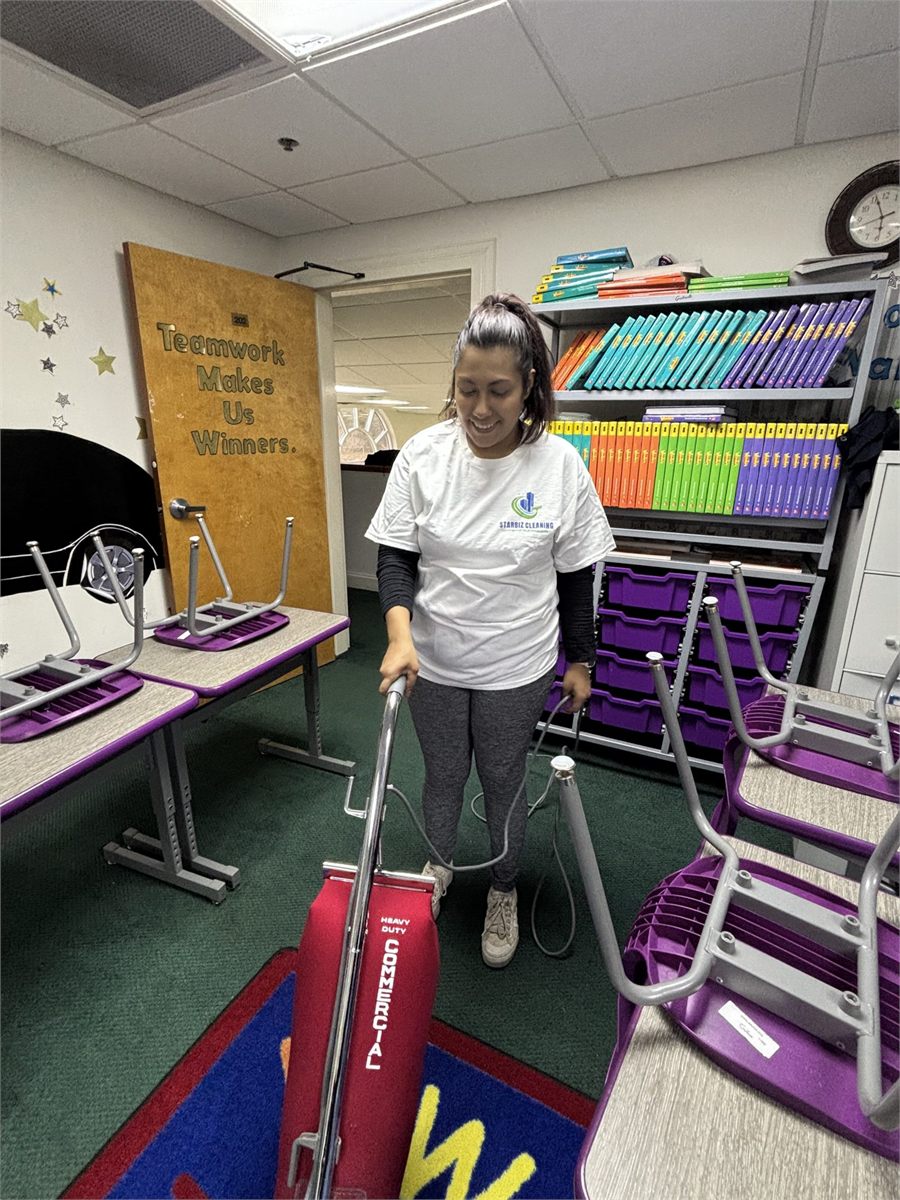 Starbiz cleaner vacuuming a school gymnasium